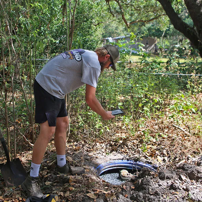 Technician performing a routine aerobic septic maintenance inspection in Comal County, Texas